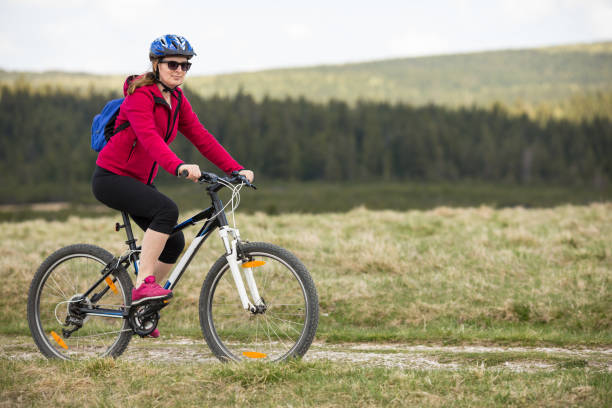 istock Woman riding bike on forest trails 1030256020