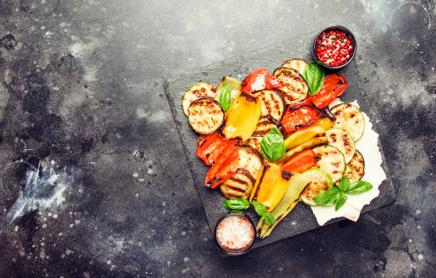 istock Grilled multicolored vegetables, aubergines, zucchini, pepper with green basil on serving stone board 1030259462