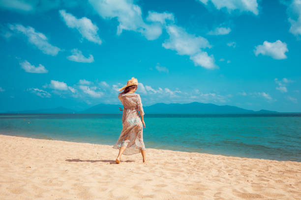 istock Woman walking on the beach 1030260312
