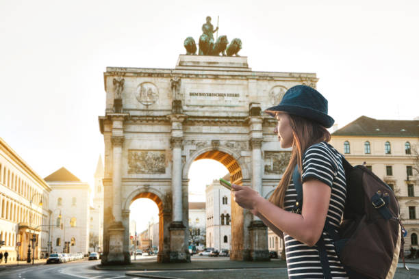 una chica de turista con una mochila parece monumentos en munich en alemania - mochilero fotografías e imágenes de stock