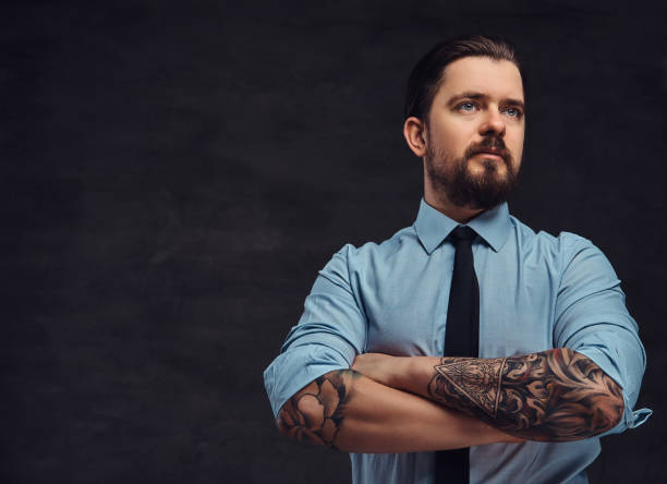 Portrait Of A Tattooed Handsome Middleaged Man With Beard And Hairstyle  Dressed In A Blue Shirt And Tie Pose In A Studio With Crossed Arms Stock  Photo - Download Image Now - iStock