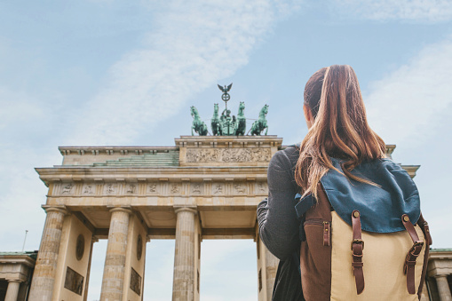 Una chica de turista con una mochila en la puerta de Brandenburgo en Berlín photo