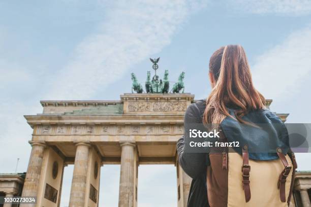 A Tourist Girl With A Backpack Looking At The Brandenburg Gate In Berlin Stock Photo - Download Image Now
