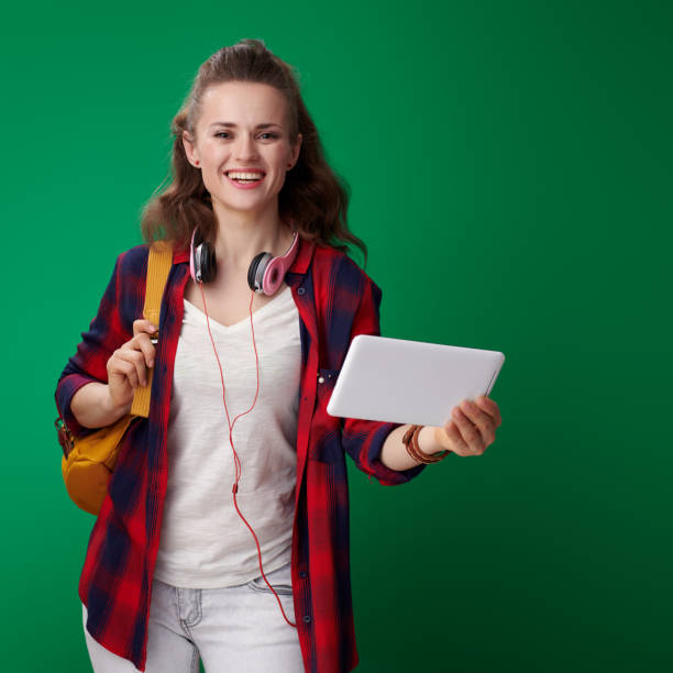 istock smiling modern student woman with tablet PC isolated on green 1030274384