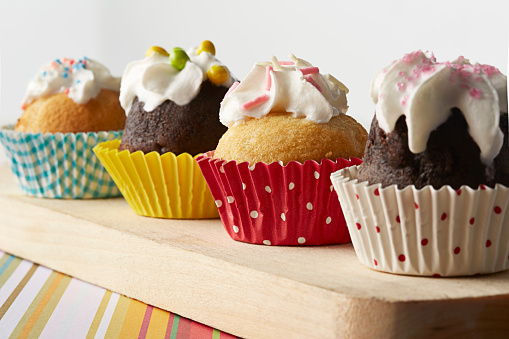 Four cupcakes on the wooden background.