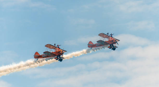 two wing walkers on old biplanes at the bournemouth air festival - stunt airplane air air vehicle imagens e fotografias de stock