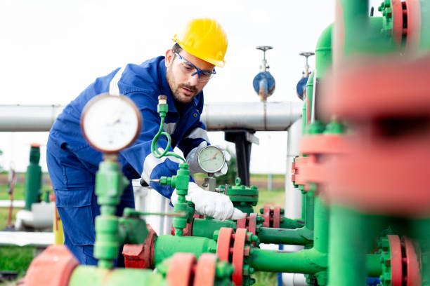 istock Worker adjusting gauge at oil refinery 1030288418