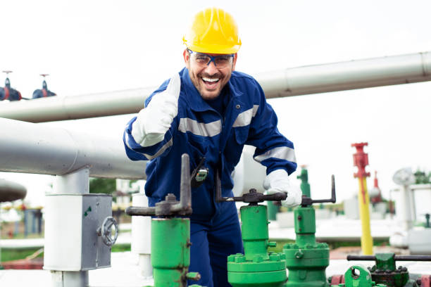 istock Worker adjusting gauge at oil refinery 1030288444