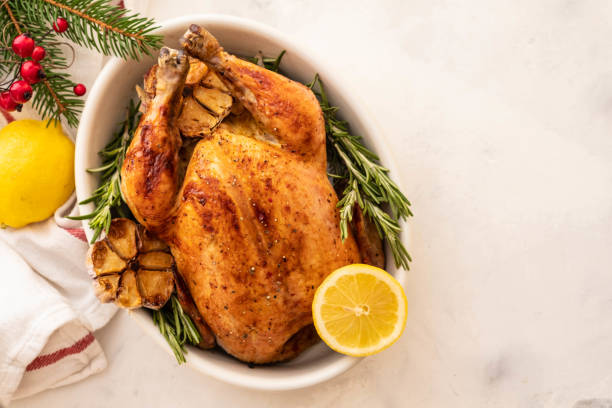 Roast chicken with lemons, garlic and rosemary for Christmas. Christmas concept. Top view. Roast chicken with lemons and rosemary for Christmas. celebrity roast stock pictures, royalty-free photos & images