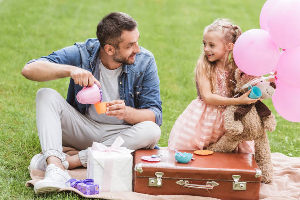istock father and daughter playing tea party at lawn 1030294692
