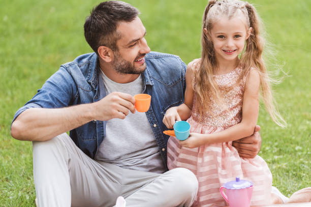 istock father and daughter playing tea party at lawn 1030294732