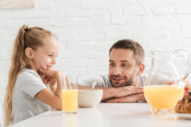 istock father and daughter drinking orange juice at kitchen 1030294804