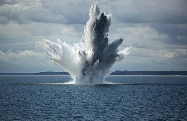 huge water fountain caused by an below surface explosion of a sea mine in the ocean - underwater mine imagens e fotografias de stock