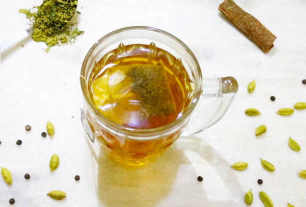 organiczna zielona herbata w szklanym kubku miód & tulsi z cinnamon stick, cardamon, czarny pieprz - green tea tea teabag green zdjęcia i obrazy z banku zdjęć