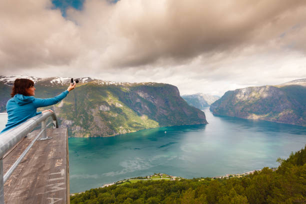 istock Tourist taking photo from Stegastein viewpoint Norway 1030311536