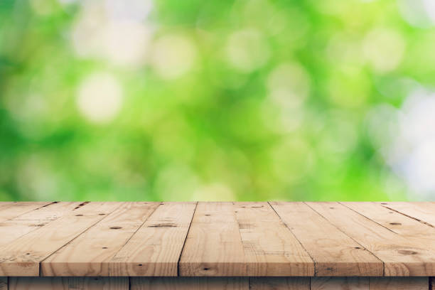 istock Empty wooden table top and green bokeh display montage for product with space. 1030314292