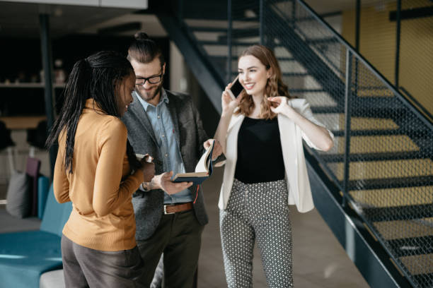 istock Happy young businesswoman talking on a phone while working with her team 1030323964