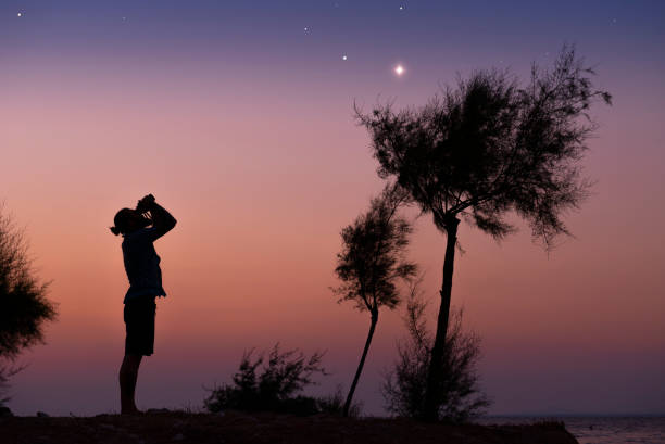 A man observing the night sky A man observing the night sky. binocular night stock pictures, royalty-free photos & images