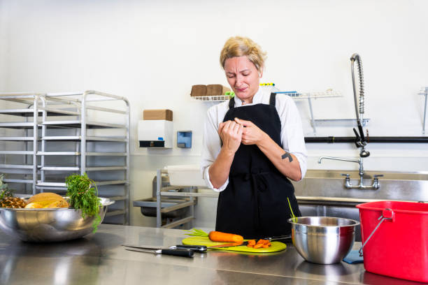istock A female chef accidentally cuts her finger in a commercial kitchen while preparing food. 1030329328