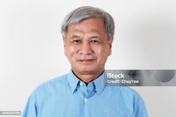 Portrait Of Attractive Senior Asian Man Smiling And Looking At Camera In Studio With White Isolated Background Feeling Positive Grandpa Headshot Of Mature Older Chinese Man Or Father Concept Stock Photo - Download Image Now