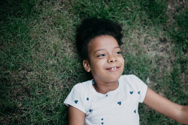 istock Cute girl laying in grass 1030349508