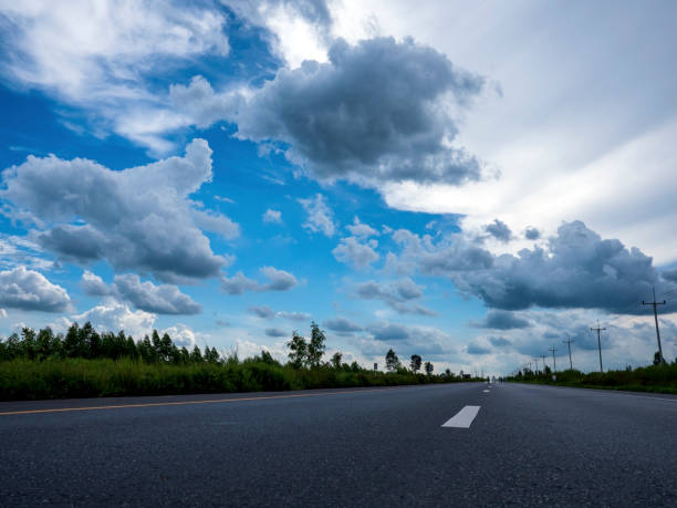 asphalte de la voiture et des nuages sur le ciel bleu en jour d’été - car street horizon over land sky photos et images de collection