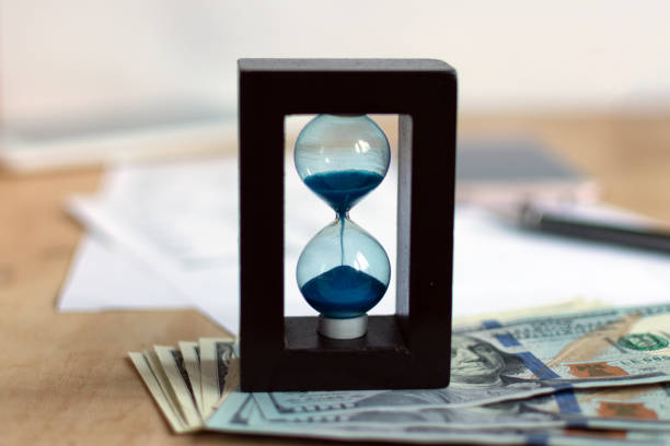 istock Hourglass and currency. 1030349938