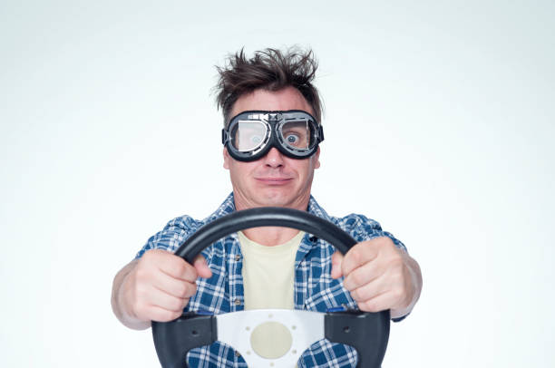 istock Man in plain shirt and stylish goggles with steering wheel, front view. Car driver concept 1030355178