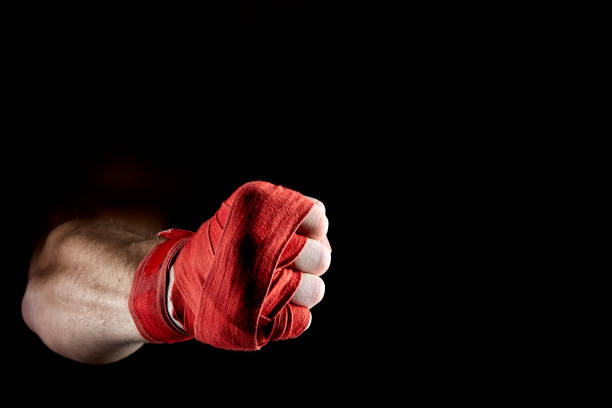 istock A boxer's red bandage on his hand isolated on dark blurred background, close-up. 1030358284