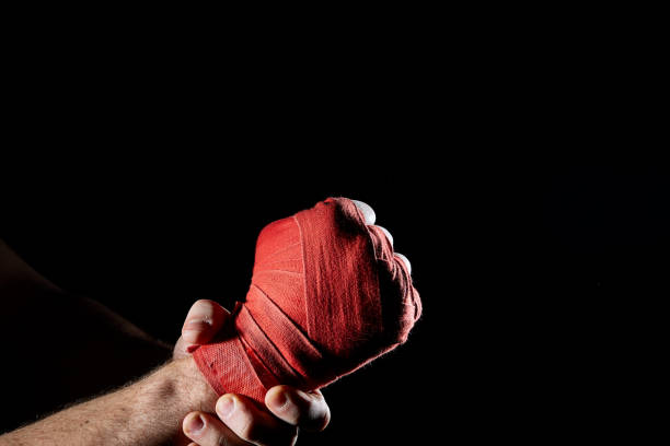 istock A boxer's red bandage on his hand isolated on dark blurred background, close-up. 1030358334