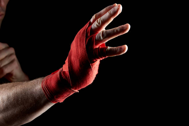 istock A boxer's red bandage on his hand isolated on dark blurred background, close-up. 1030358444