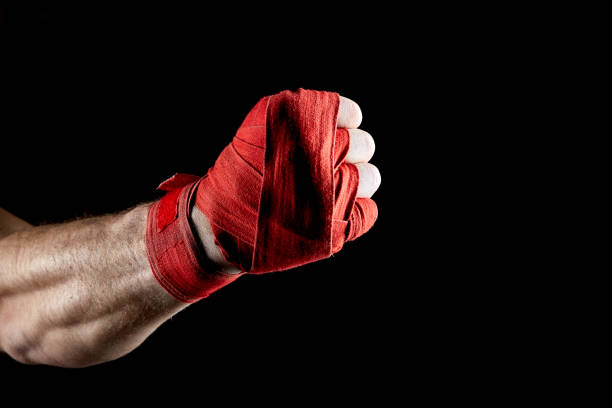 istock A boxer's red bandage on his hand isolated on dark blurred background, close-up. 1030358486