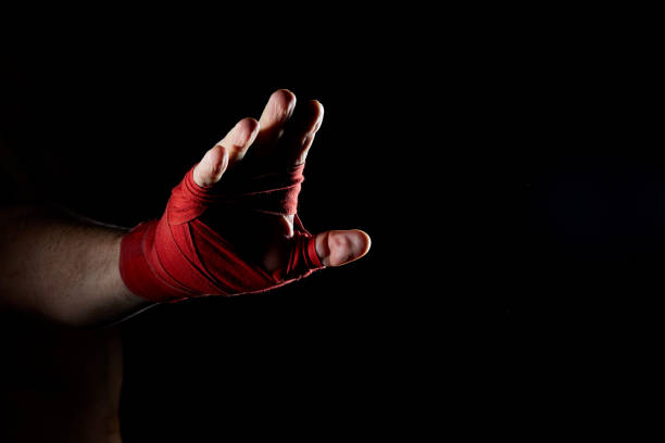 istock A boxer's red bandage on his hand isolated on dark blurred background, close-up. 1030358534