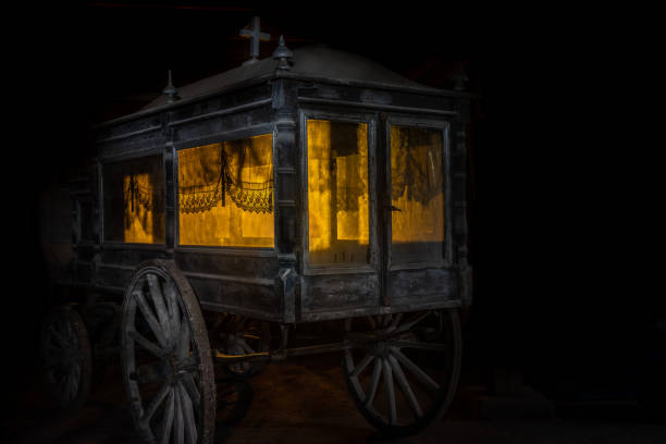 Very old and dusty hearse made of wood with large wooden wheels. Used to transport the coffin with the dead during the funeral in the late 18th century.