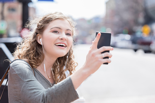 Mujer joven utiliza aplicación móvil a pasear photo
