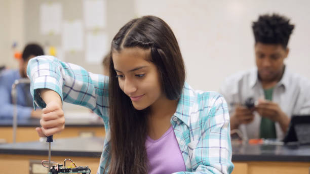 istock Confident schoolgirl builds robot 1030375018