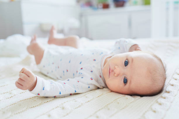 istock Adorable baby girl lying on bed 1030375652