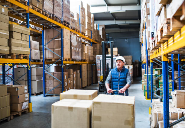 istock Senior male warehouse worker pulling a pallet truck. 1030380156
