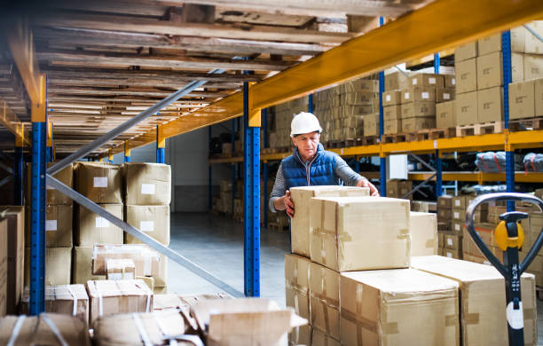 istock Senior male warehouse worker unloading boxes from a pallet truck. 1030380234