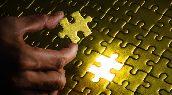 Different many blue puzzle pieces on white table background. Closeup. Top down view. Jigsaw wide banner. Empty place for text.