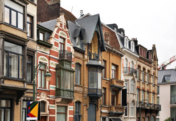 Historic European townhouses: one half-timbered style, the other red brick Neo-Renaissance, featuring intricate gables against a clear blue sky in Antwerp, Belgium. High quality photo