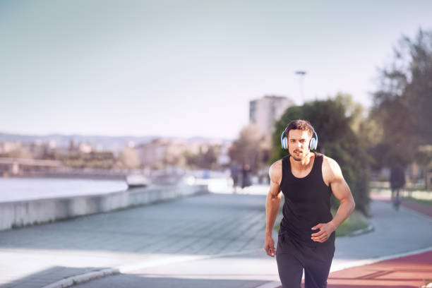 istock Urban runner jogging in city next river 1030386800