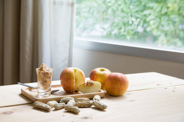 istock Apples with peanut butter on wooden table 1030387792
