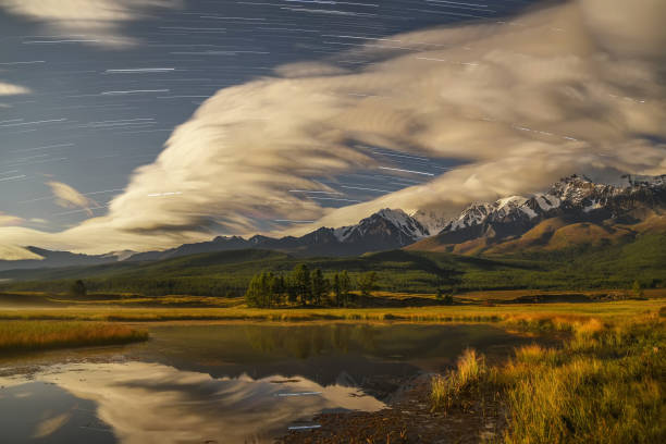 istock lake mountains stars tracks clouds sky 1030389870