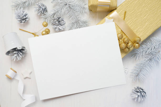 istock abstract christmas background, white sheet of paper lying among small decorations on white wooden desk. Flat lay mockup for your art, picture or hand lettering composition copy space, top view 1030389900