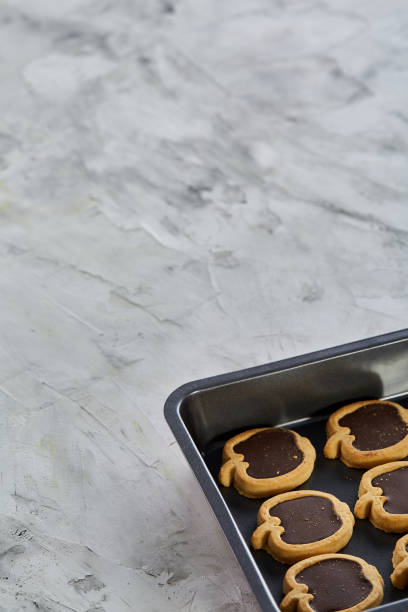 istock Fresh baked chocolate apple shaped cookies on a cookie sheet, top view, close-up, selective focus 1030394248