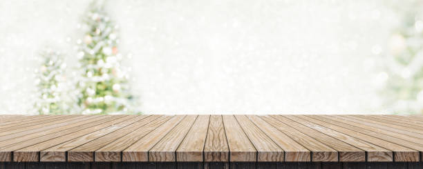istock Empty brown wooden table top with abstract muted blur christmas tree and snow fall background with bokeh light,Holiday backdrop,Mock up banner for display or montage of product. 1030395382