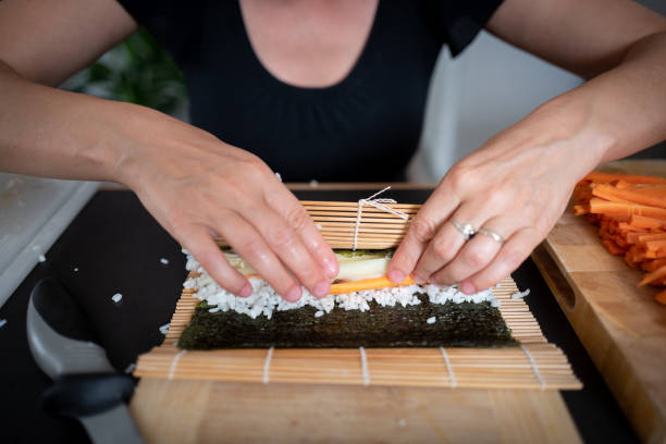 istock Woman making at home Japanese sushi rolls 1030405472
