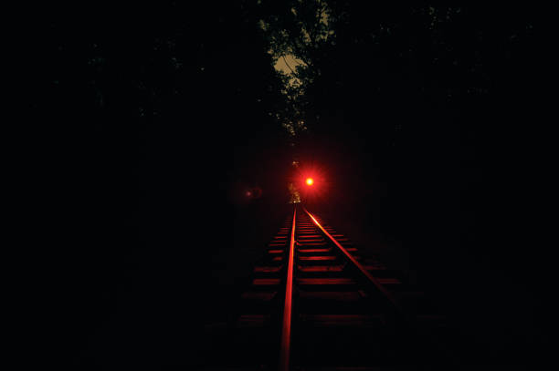 istock Railroad track at night. red light is on. 1030405638