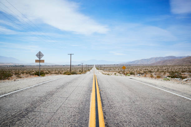 istock Country Road Through Desert Looking Towards Horizon 1030407940